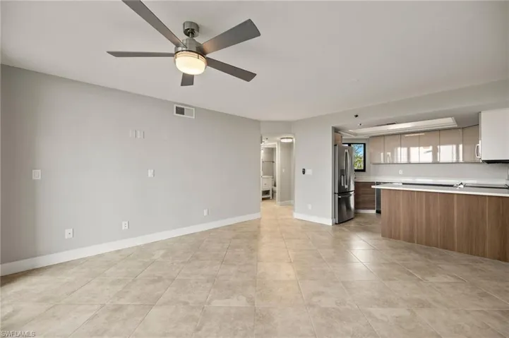 Unfurnished living room with light tile patterned floors and ceiling fan