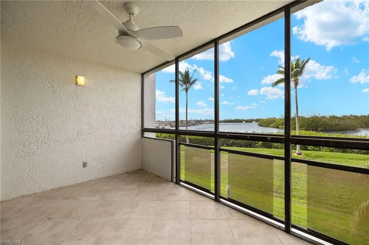 Unfurnished sunroom with a water view and ceiling fan