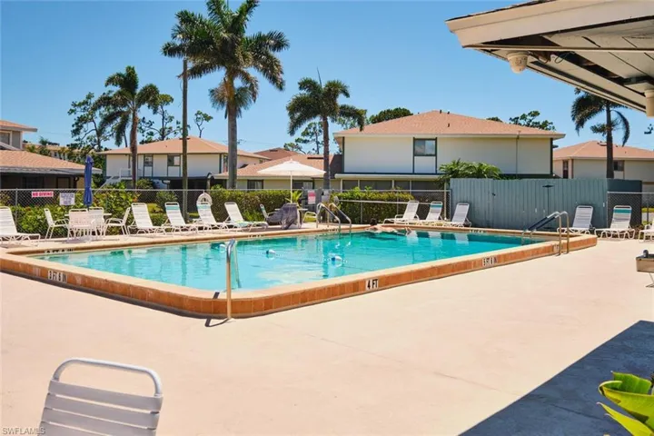 Community pool with a patio area and a residential view