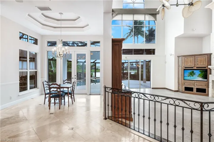 Lovely breakfast area has double tray ceilings, access out to your pool deck.