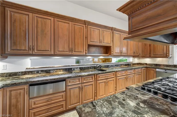 Appliances with stainless steel finishes, marble countertops, custom cabinetry.