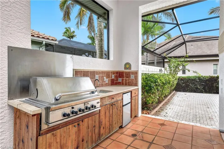 Outdoor kitchen is under truss. Access to your outdoor kitchen is either through the dining area or through any number of sliders that open to the lanai and pool deck.