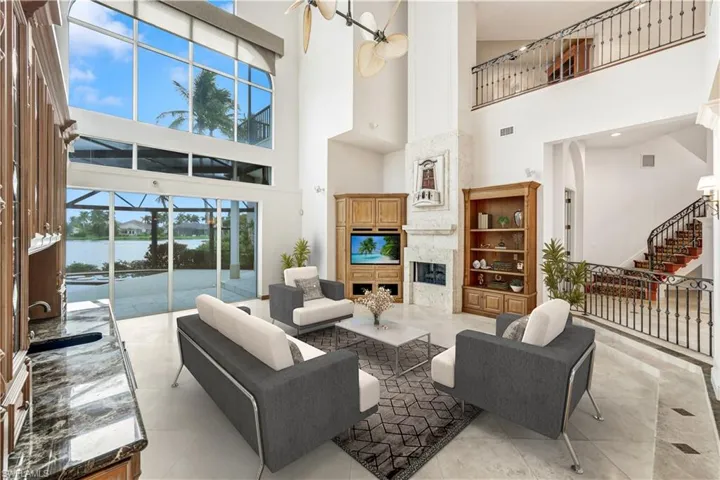 Virtually staged living room with 32 ft. ceilings, bar area, sliders that completely pocket back on both sides, transom windows to allow for enormous amount of natural light to spill in!