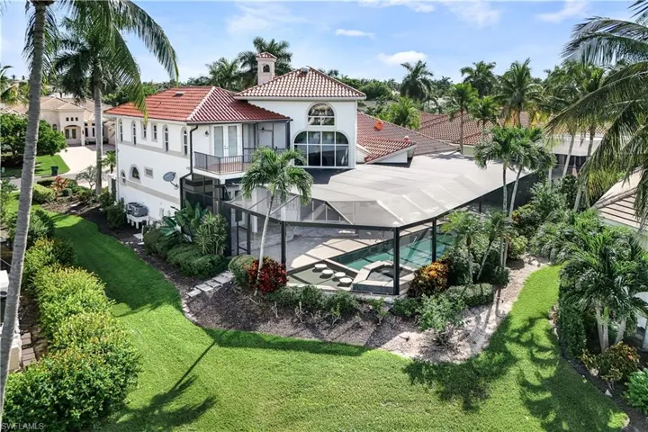Rear view of property featuring a balcony and a yard