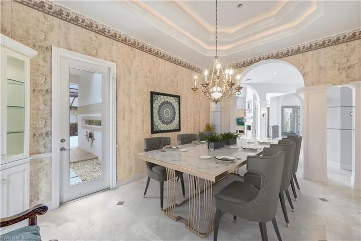 Virtually staged dining area has access to the outdoor kitchen area and pool deck and lanai. Double uplighted tray ceiling.