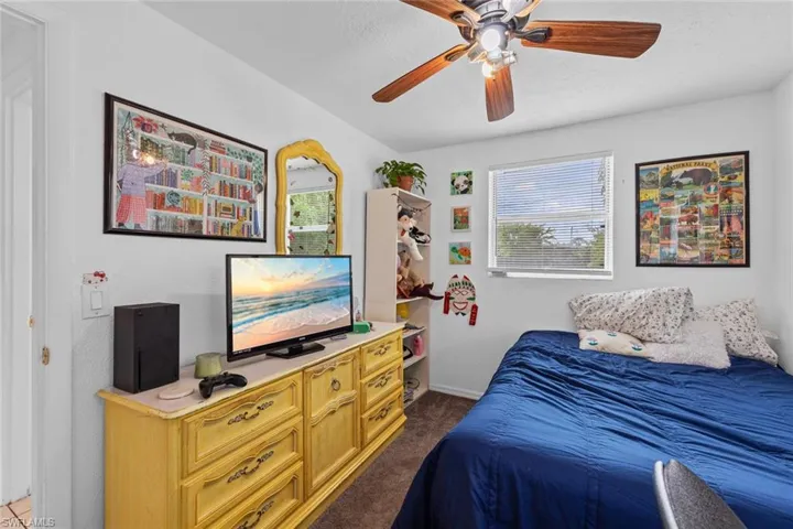 Bedroom with dark colored carpet and ceiling fan