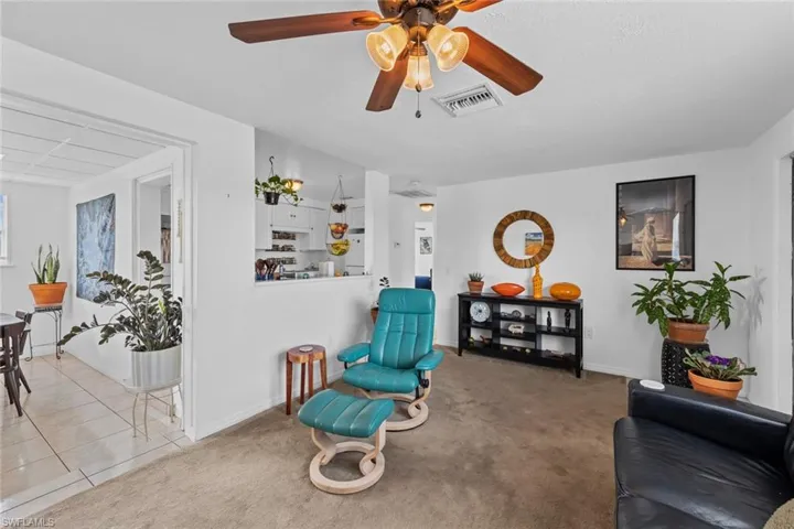 Living area with ceiling fan and carpet floors