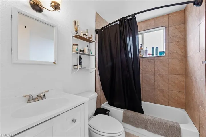 Full bathroom featuring vanity, shower / bath combo, and toilet