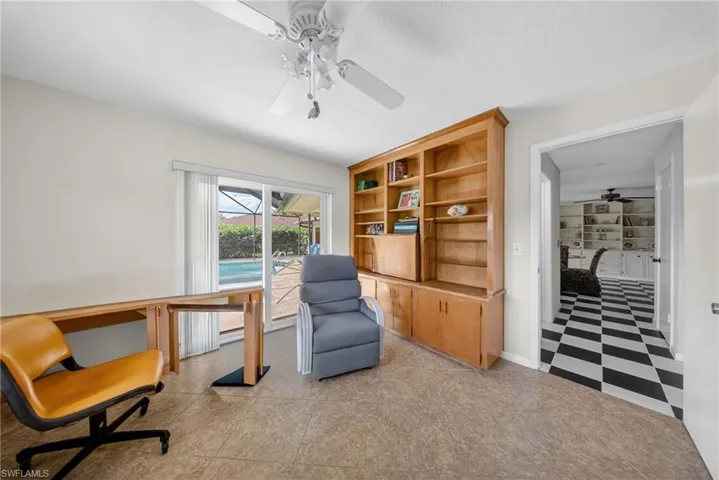 Living area with ceiling fan, light flooring, and a textured ceiling