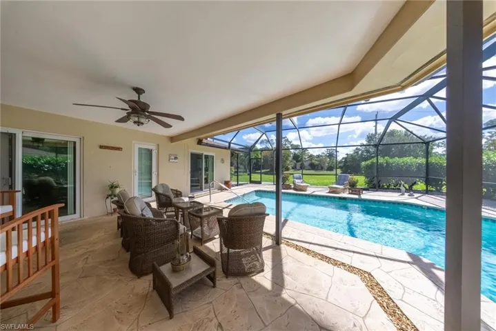 Swimming pool featuring a patio, a sunroom, and glass enclosure