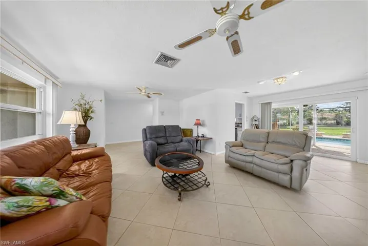 Living area featuring ceiling fan and light tile patterned floors