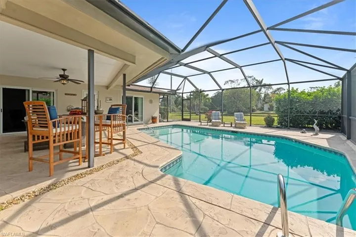 Outdoor pool with a patio, a ceiling fan, and glass enclosure