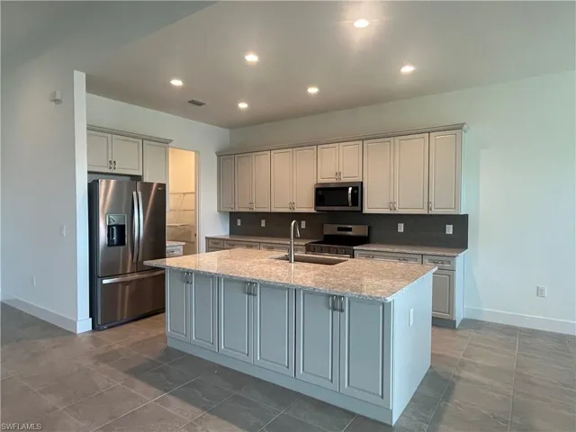 Gorgeous, kitchen layout with quartz countertops, suite of stainless steel appliances, and soft-close cabinetry