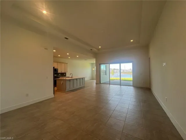 Great room living space with tray ceiling and large, sliding glass doors