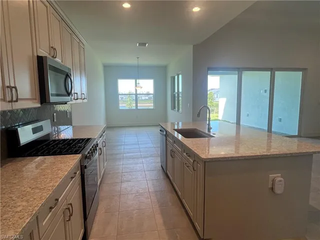 Gorgeous, kitchen layout with quartz countertops, suite of stainless steel appliances, and soft-close cabinetry