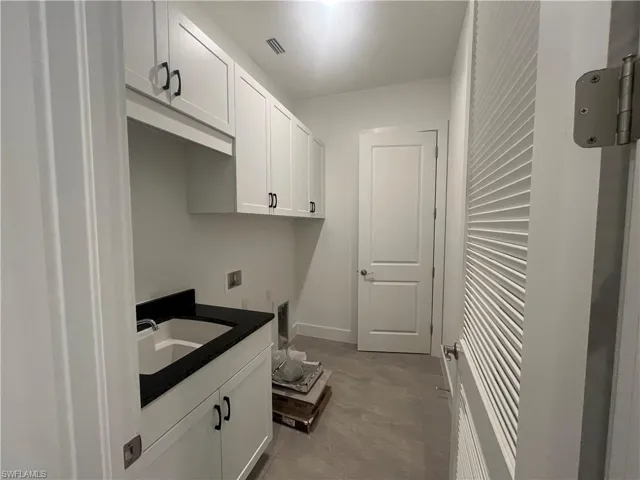Laundry room with utility sink and ample cabinetry