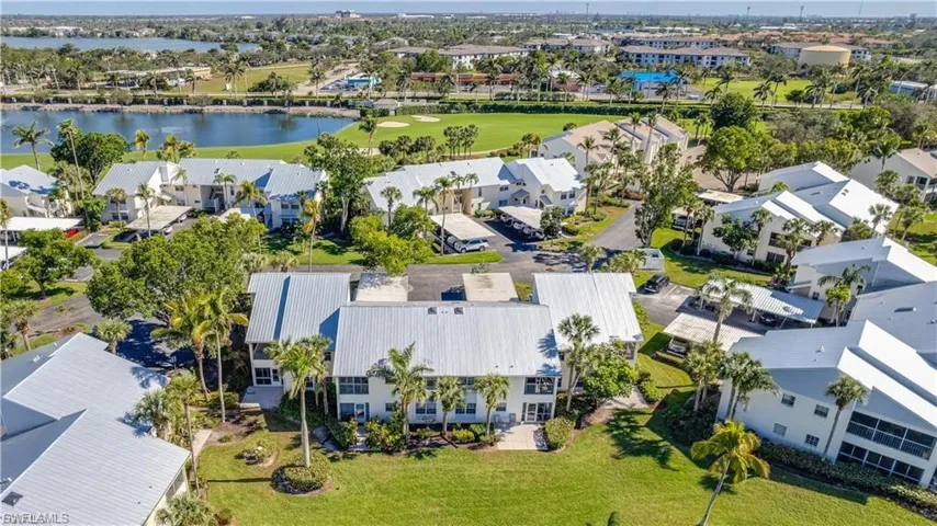 Aerial perspective of suburban area featuring a local golf course and a large body of water
