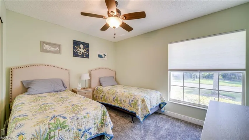 Carpeted bedroom featuring a textured ceiling and ceiling fan