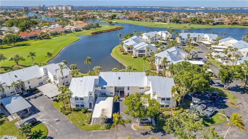 Aerial view of residential area with a golf course and a large body of water