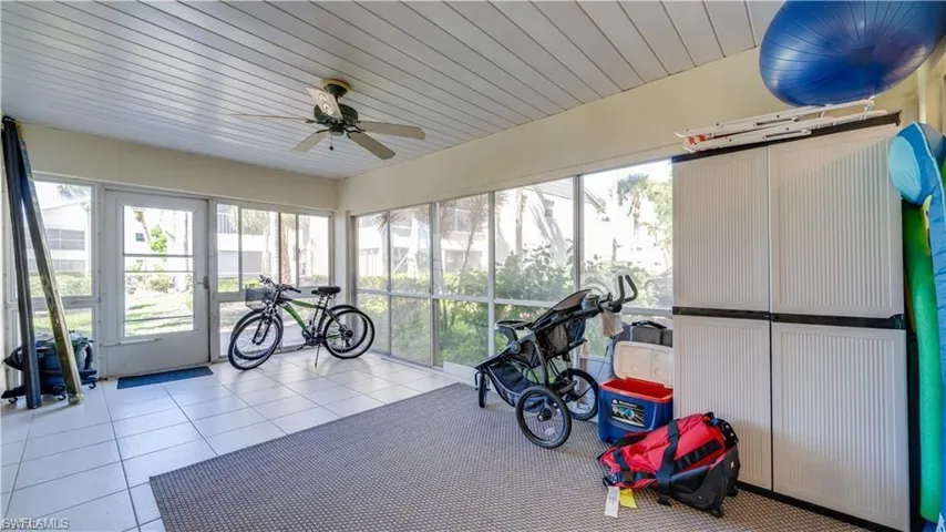 Workout room with tile patterned flooring, wooden ceiling, a ceiling fan, and plenty of natural light