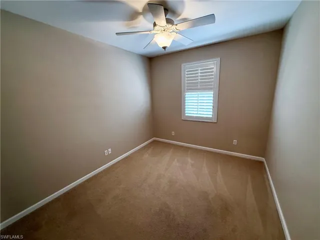Empty room with carpet floors and a ceiling fan