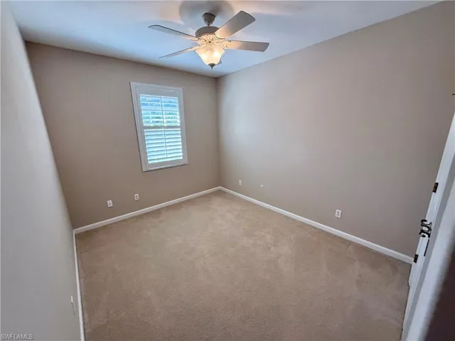 Spare room featuring carpet flooring and a ceiling fan