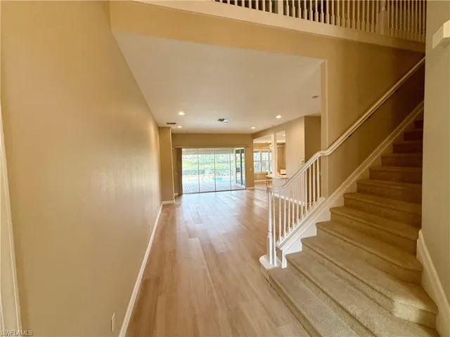 Stairway with wood finished floors and recessed lighting