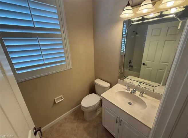 Bathroom with vanity, shower / tub combination, and light tile patterned floors