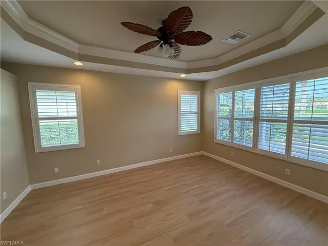 Unfurnished room with ornamental molding, a raised ceiling, light wood-style floors, ceiling fan, and recessed lighting
