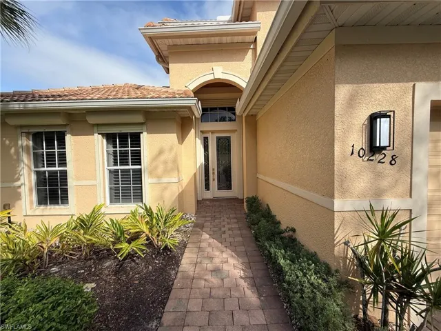Doorway to property featuring stucco siding