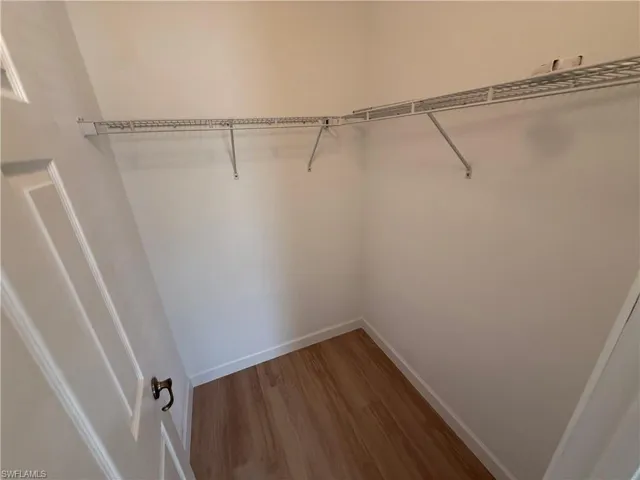 Walk in closet with light wood-type flooring