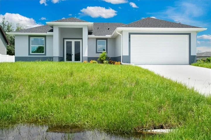 View of front of house with a garage and a front lawn