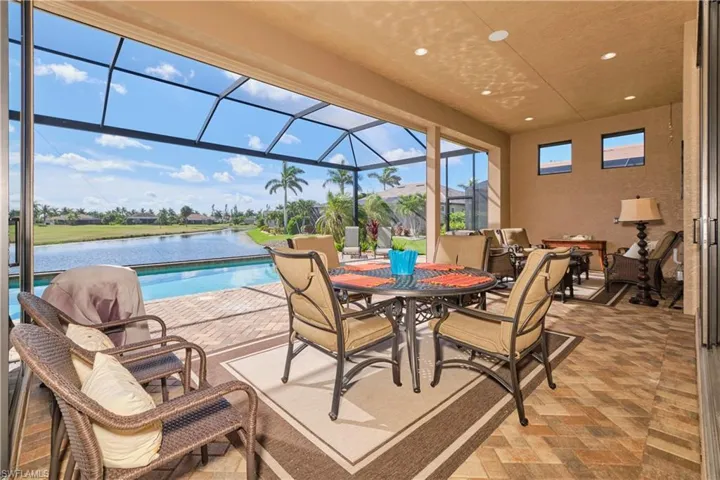 View of pool with a lanai, a water view, and a patio area
