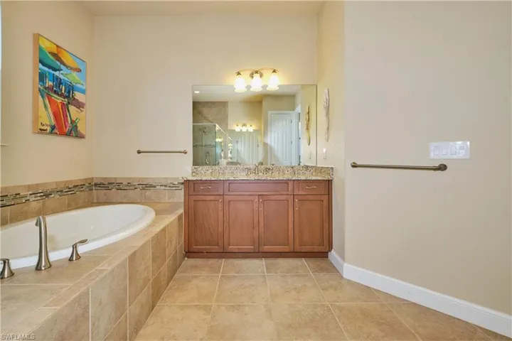 Bathroom with vanity, separate shower and tub, and tile patterned floors