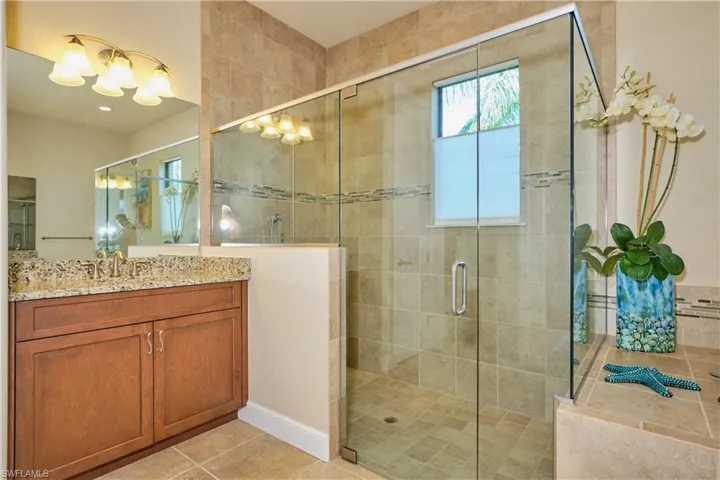 Bathroom featuring vanity, tile patterned floors, and an enclosed shower