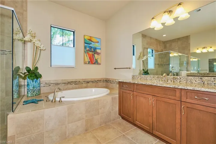 Bathroom with vanity, shower with separate bathtub, and tile patterned flooring