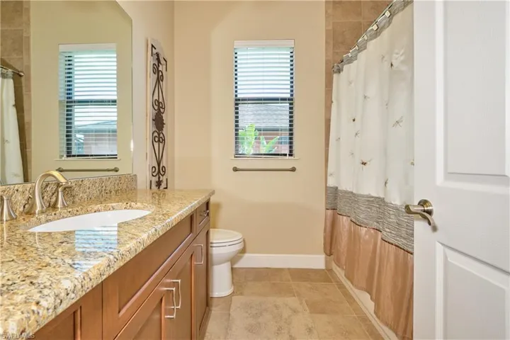 Bathroom featuring vanity, toilet, tile patterned floors, and plenty of natural light