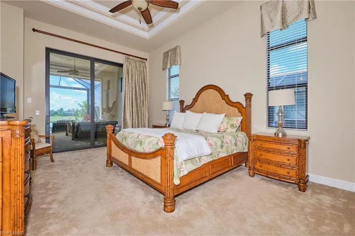Carpeted bedroom featuring access to outside, a high ceiling, crown molding, and ceiling fan