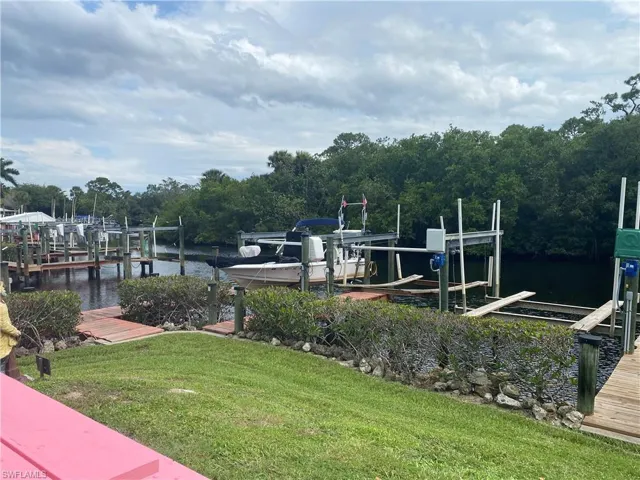 Dock area with a lawn and a water view