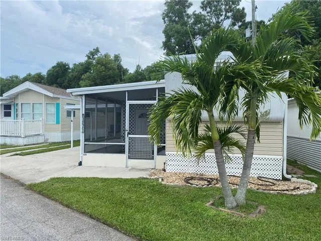 Rear view of property featuring a sunroom and a lawn
