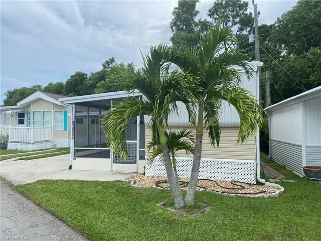 View of front of home with a front yard and a sunroom