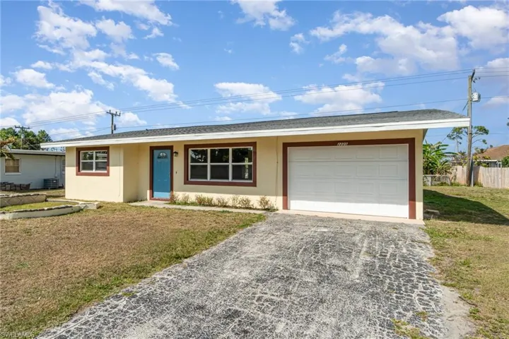 Single story home featuring gravel driveway, stucco siding, an attached garage, and a shingled roof