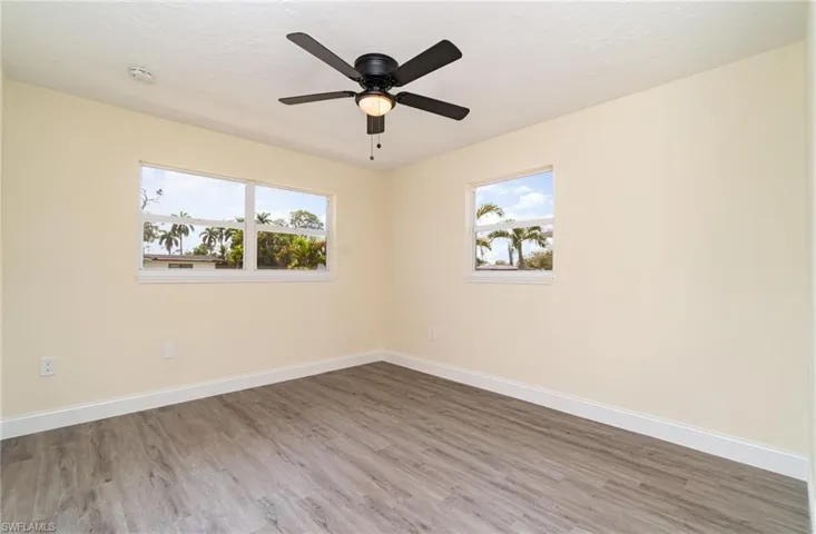 Spare room with wood finished floors, a textured ceiling, and a ceiling fan