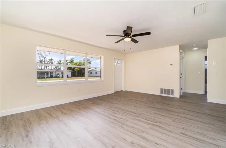 Unfurnished living room with light wood-style flooring and a ceiling fan