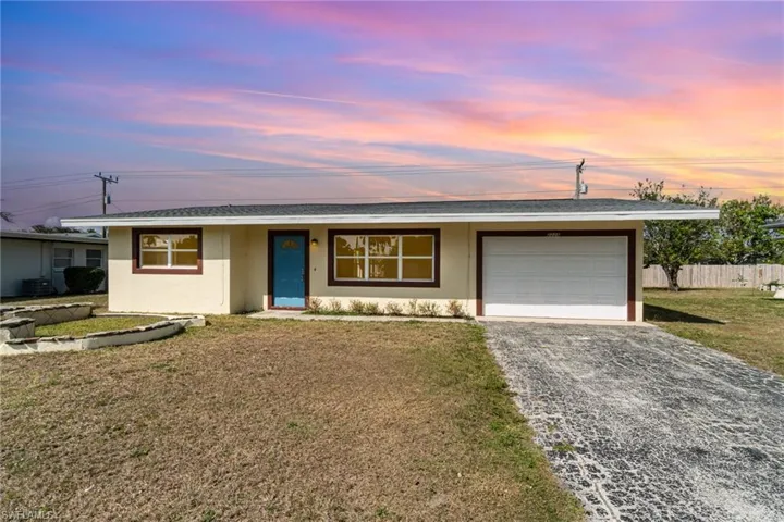 Ranch-style house featuring stucco siding, gravel driveway, a garage, and a shingled roof