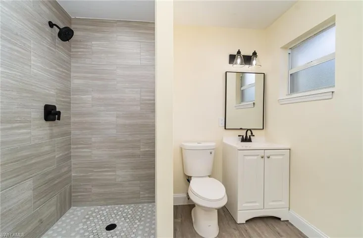 Bathroom with a shower stall, vanity, and light wood-style floors