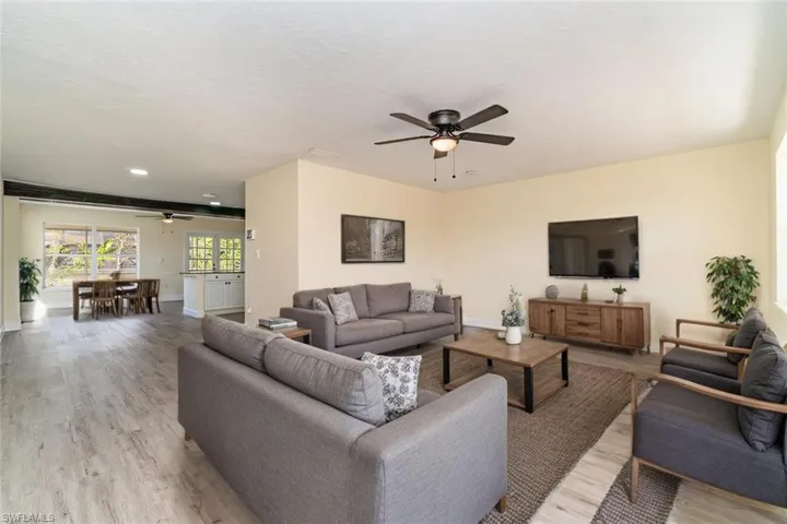 Living room featuring ceiling fan, light wood-type flooring, and a textured ceiling