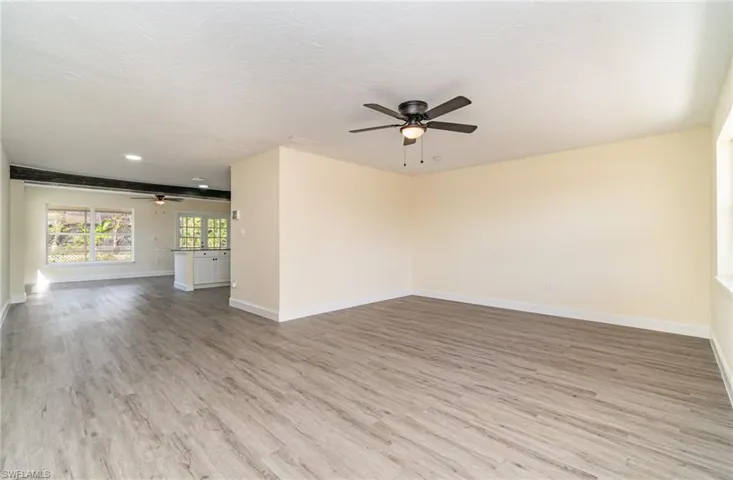 Unfurnished room featuring light wood finished floors, a ceiling fan, and a textured ceiling