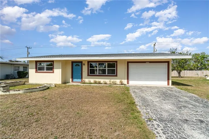 Ranch-style home with stucco siding, gravel driveway, and an attached garage