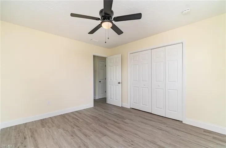 Unfurnished bedroom featuring light wood finished floors, ceiling fan, a textured ceiling, and a closet